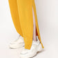 Mustard two piece set for women featuring stylish side slits and paired with trendy sneakers