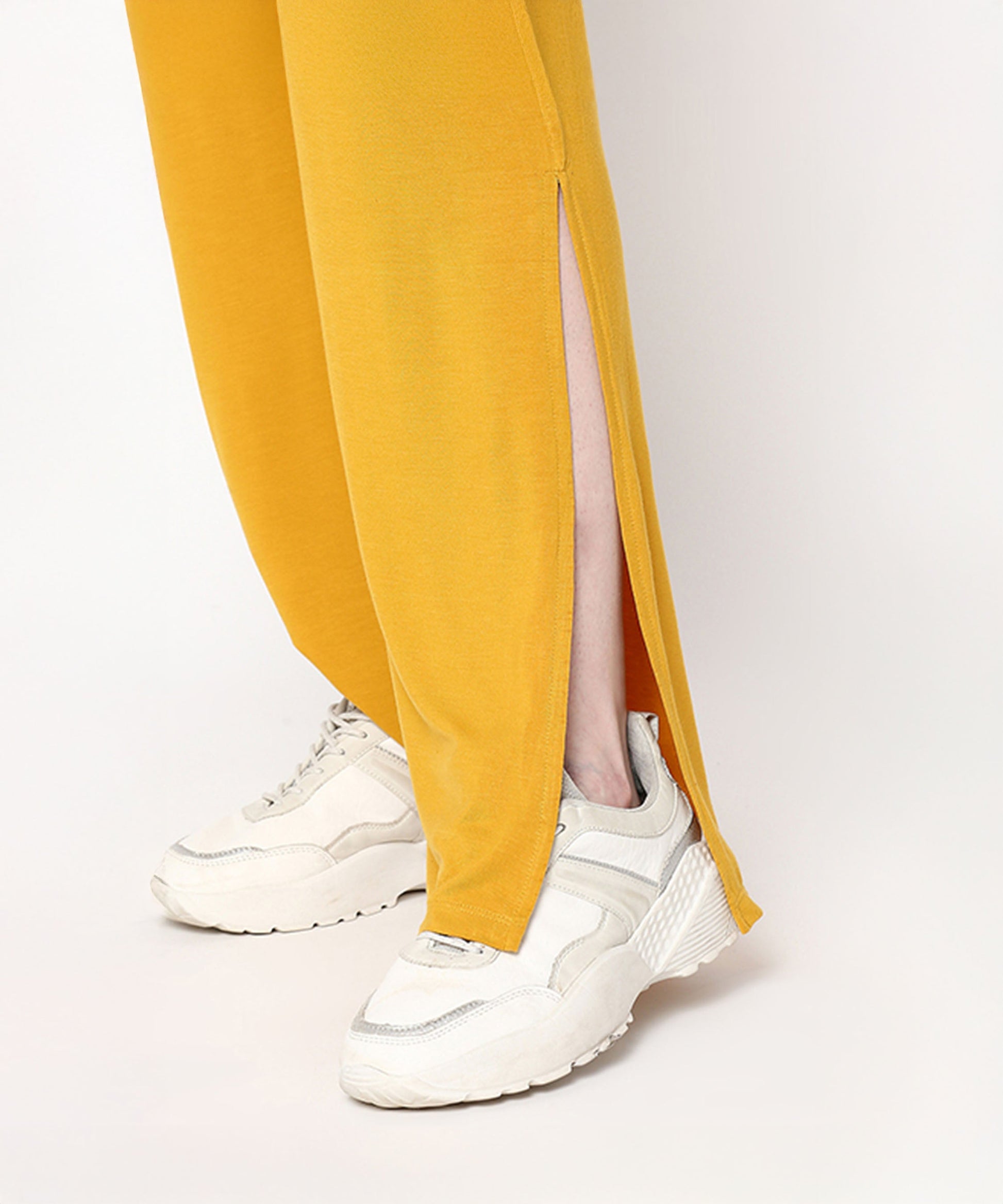 Mustard two piece set for women featuring stylish side slits and paired with trendy sneakers