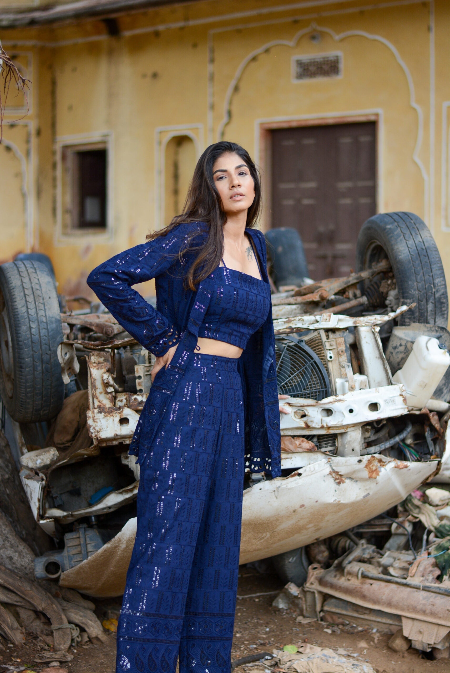 Stylish model wearing a navy blue three piece co-ord set featuring a crop top and wide-leg pants