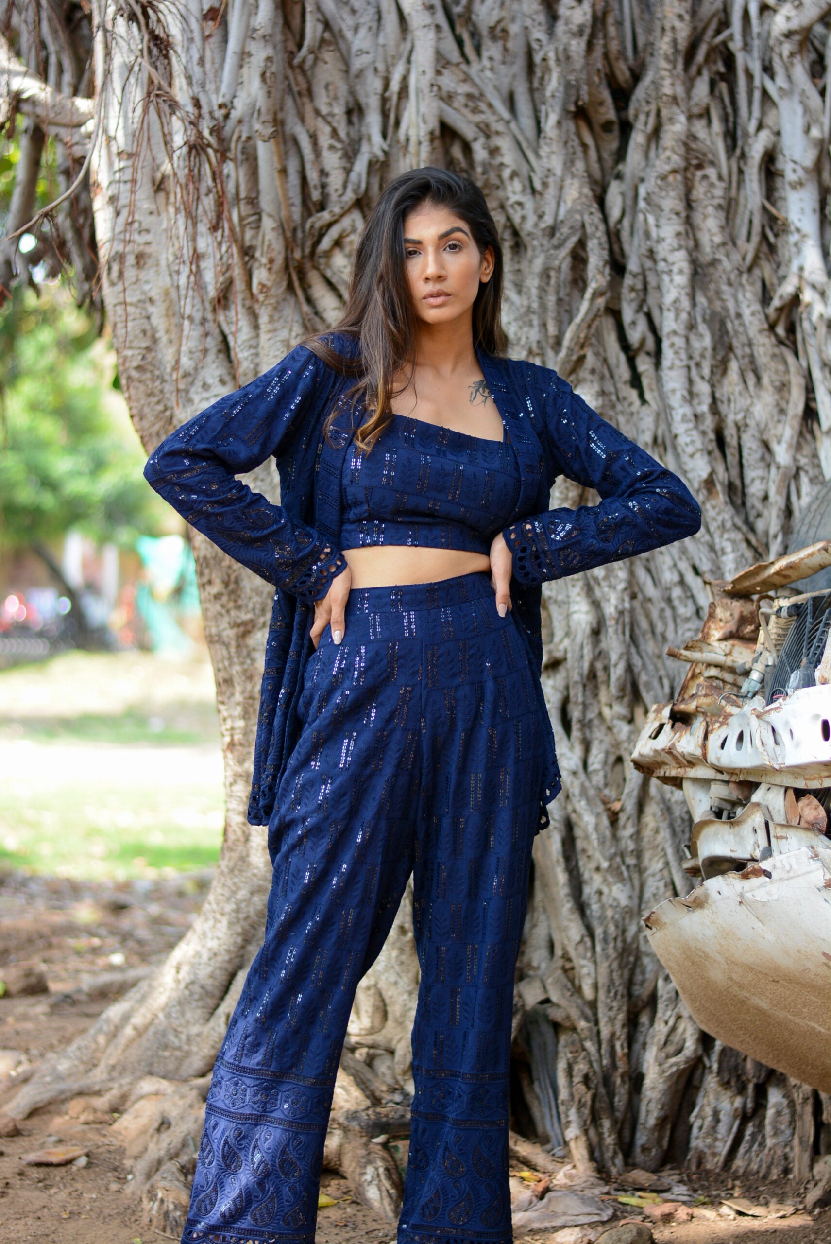 Model wearing a navy blue three piece co-ord set featuring a crop top and wide-leg pants