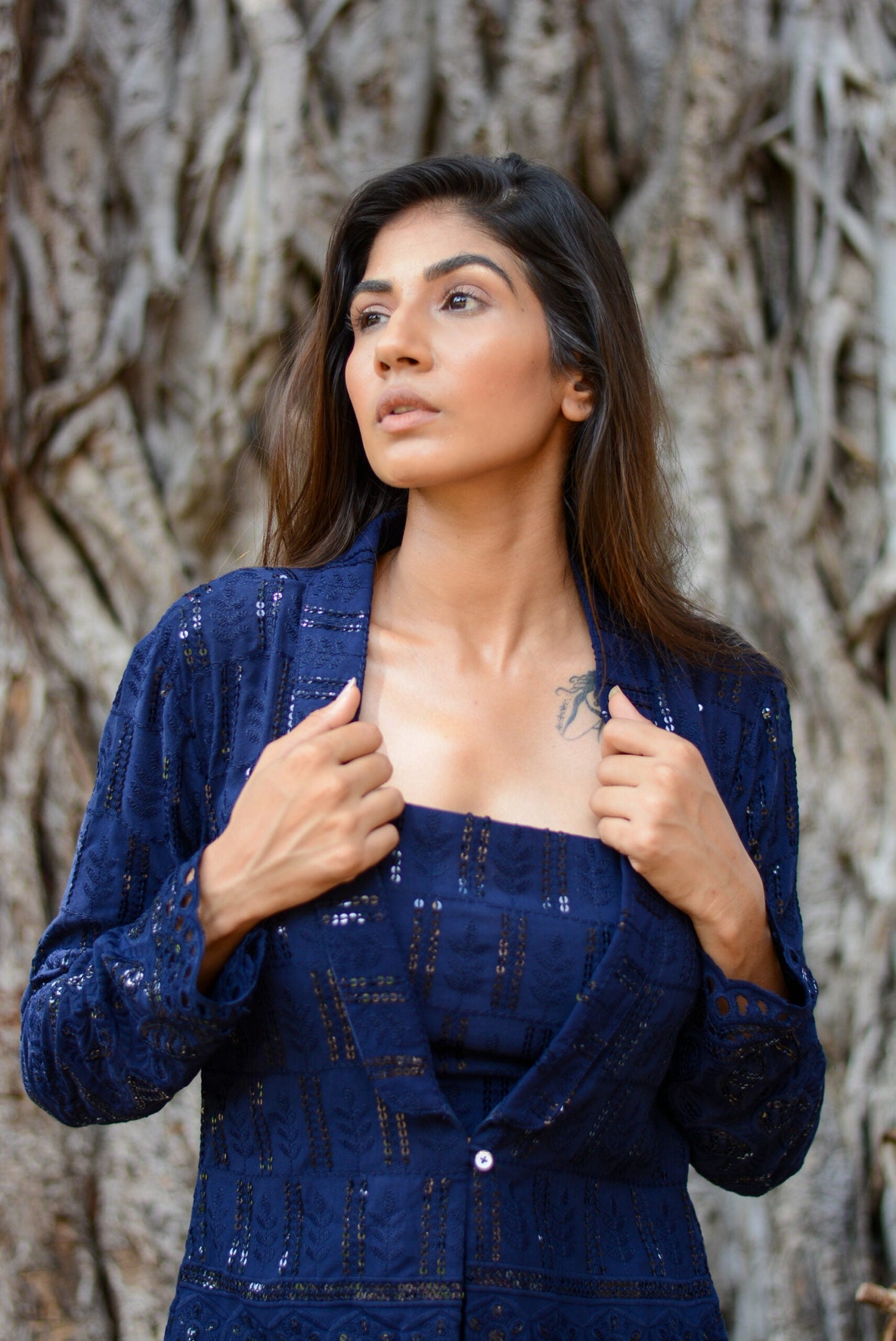 Elegant model wearing a navy blue three piece co-ord set with an open blazer and fitted top