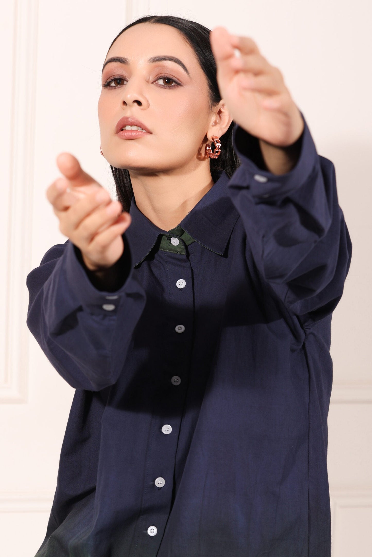 Model wearing a navy green two piece matching set with a stylish button-up shirt and relaxed fit
