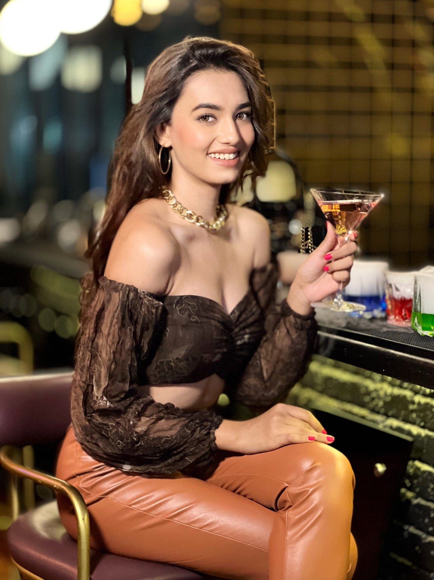 Off shoulder brown crop top for women styled with trendy accessories and elegant backdrop