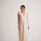 Woman wearing off-white event dress by Stylera with intricate embroidery and sleeveless design
