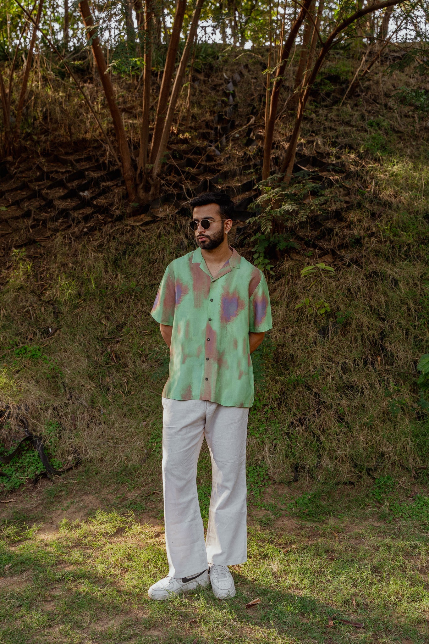 Ombre oversized shirt for men in green and purple tones, styled with white pants for a casual look
