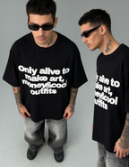 Two men wearing black t-shirts with white text, standing against a gray background.