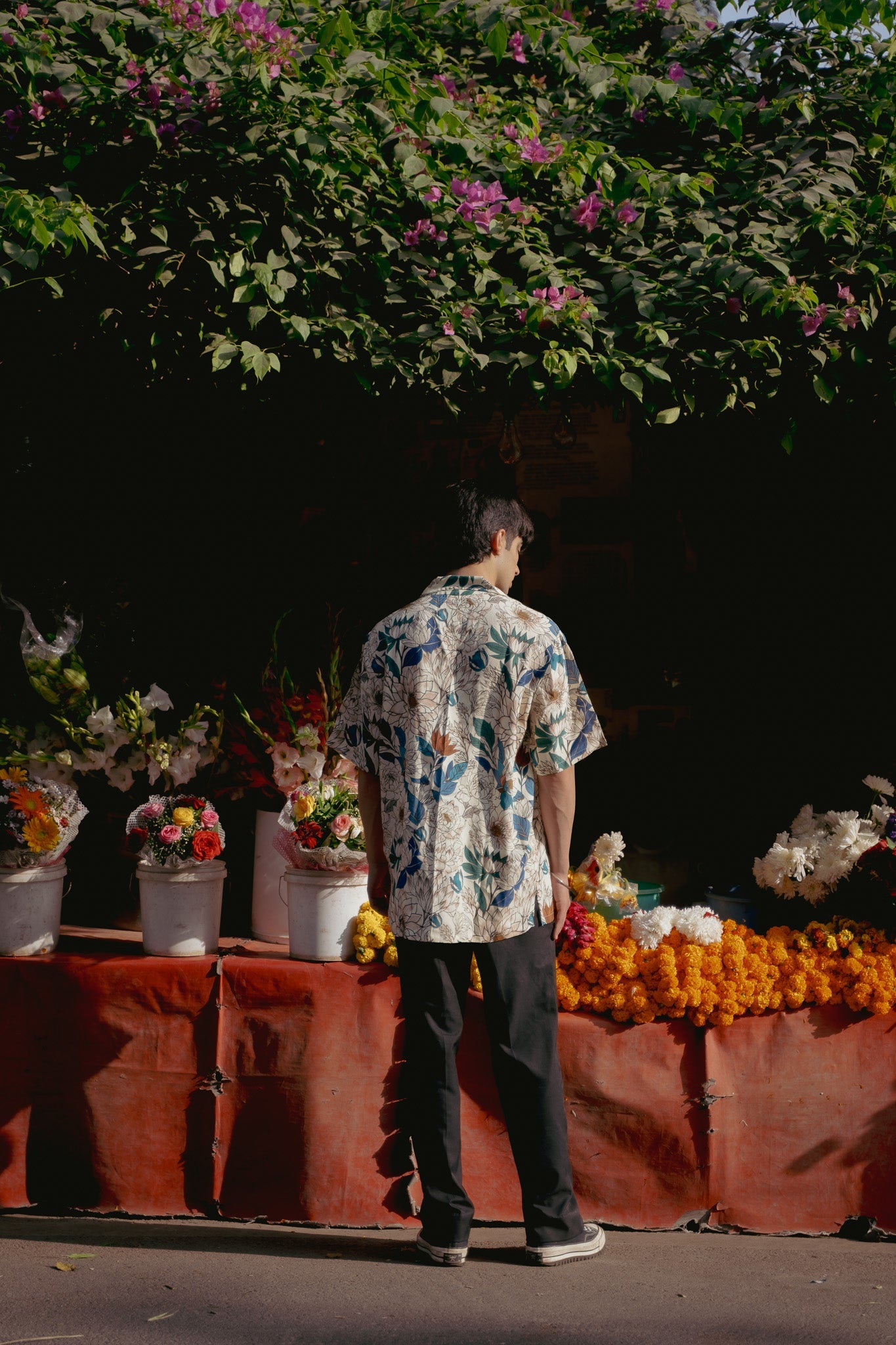 Men's oversize floral button down shirt displayed against a vibrant flower backdrop