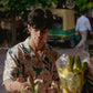 Model wearing an oversize floral button down shirt at a flower market