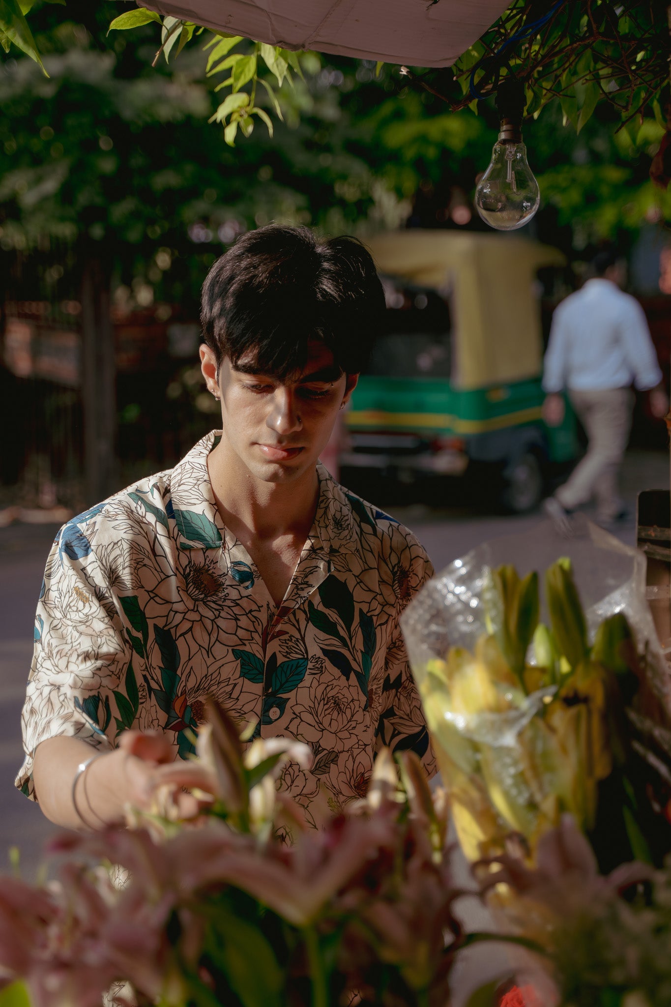 Model wearing an oversize floral button down shirt at a flower market