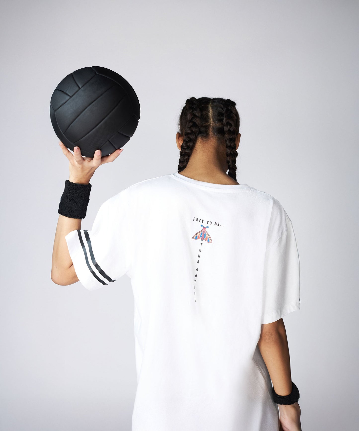 Model wearing a Stylera oversize fly tee, holding a black ball, showcasing the back design