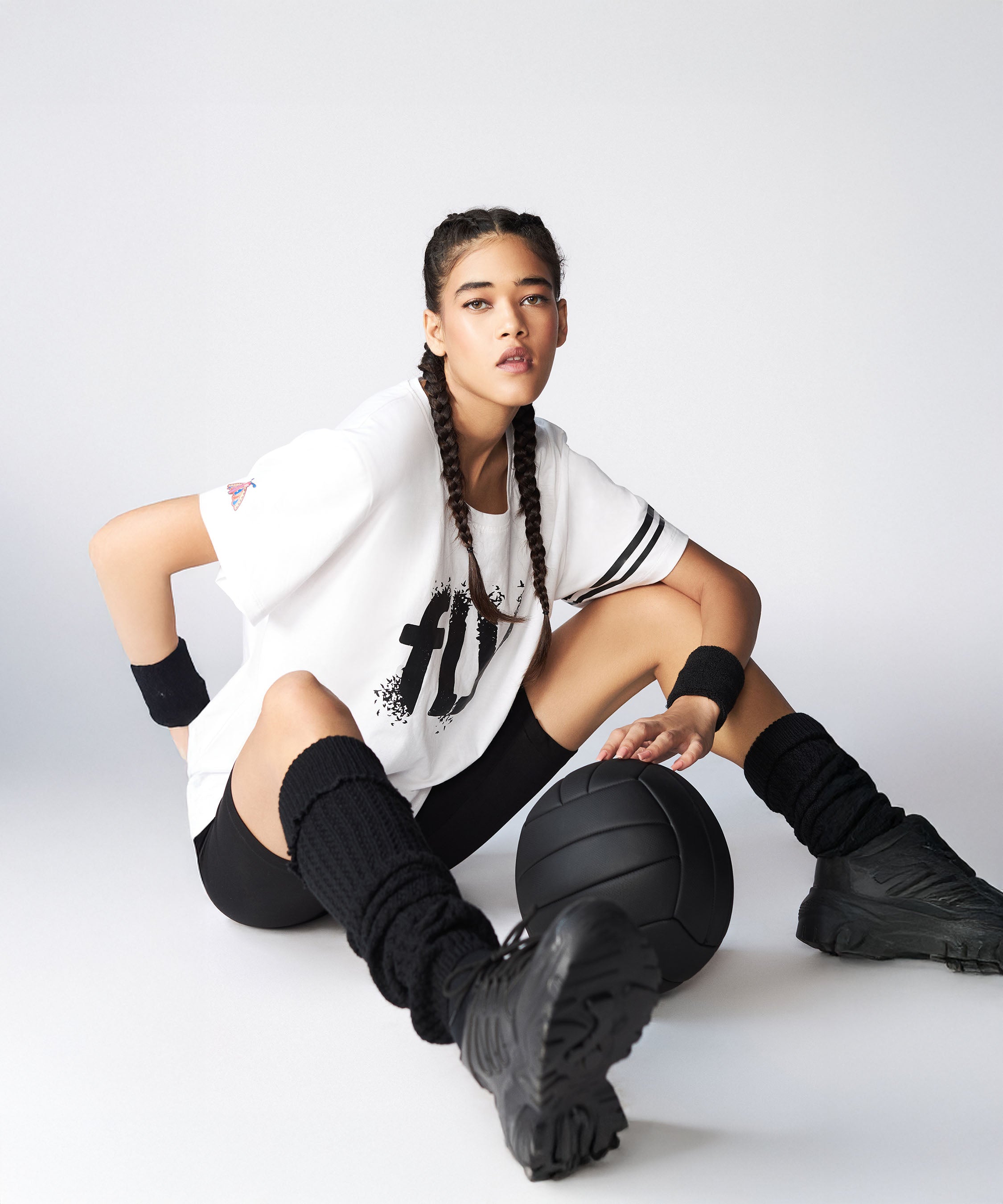 Model in an oversized fly tee from Stylera posing with a basketball, showcasing a sporty look
