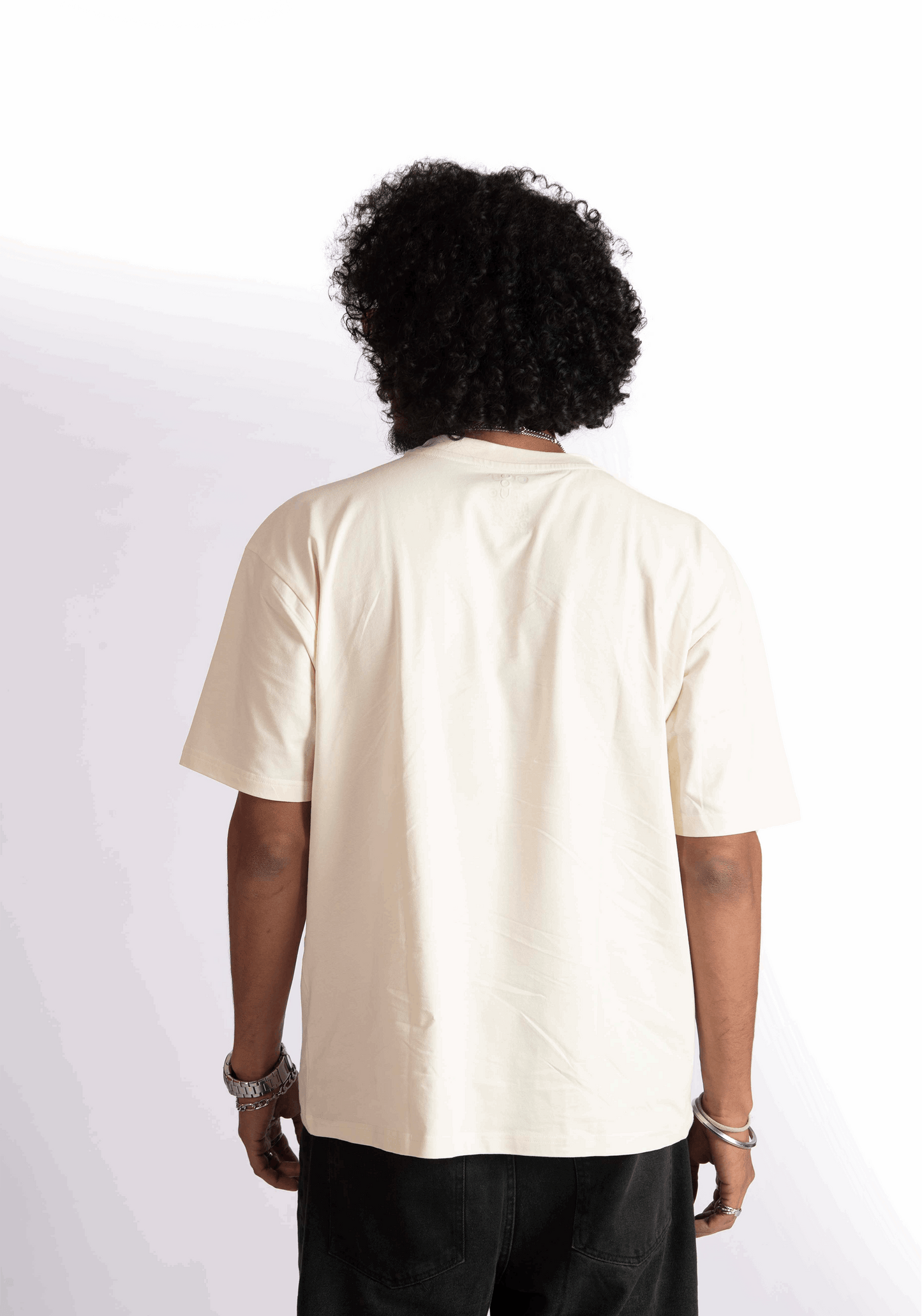 Back view of a person wearing an oversized almond milk t-shirt by Stylera in a neutral color