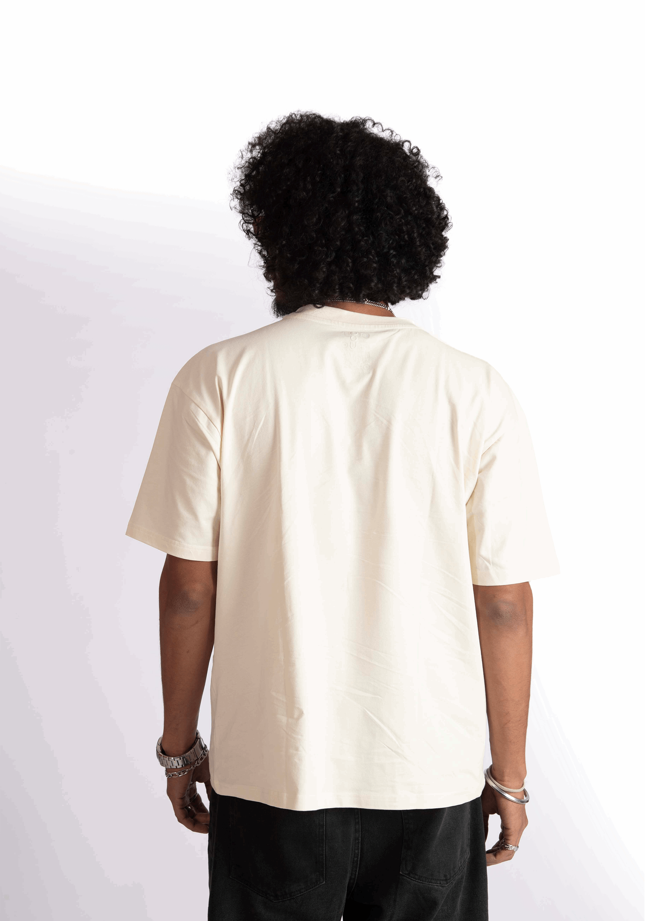 Back view of a person wearing an oversized almond milk t-shirt by Stylera in a neutral color