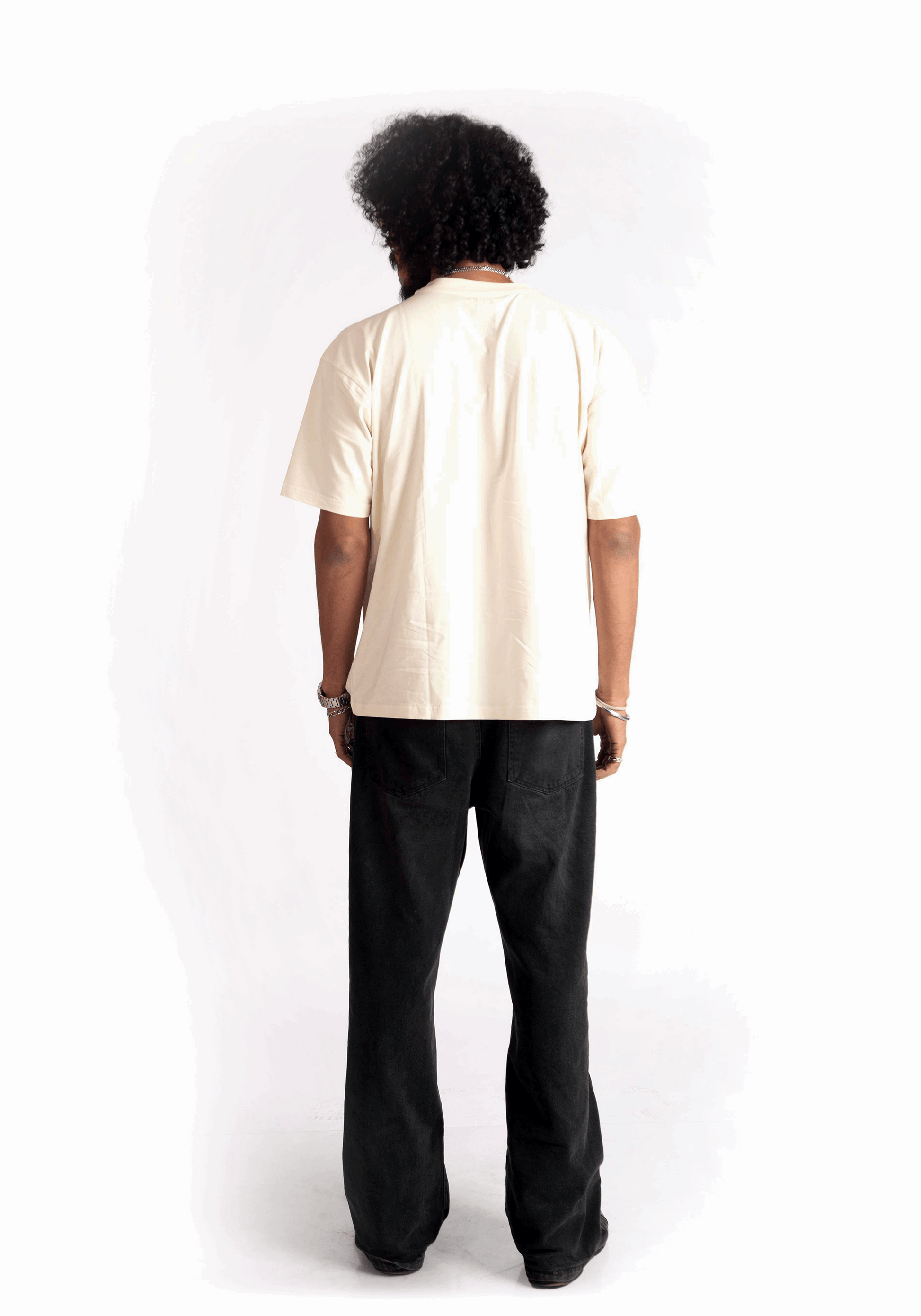 Back view of a person wearing Stylera oversized almond milk t-shirt with black pants