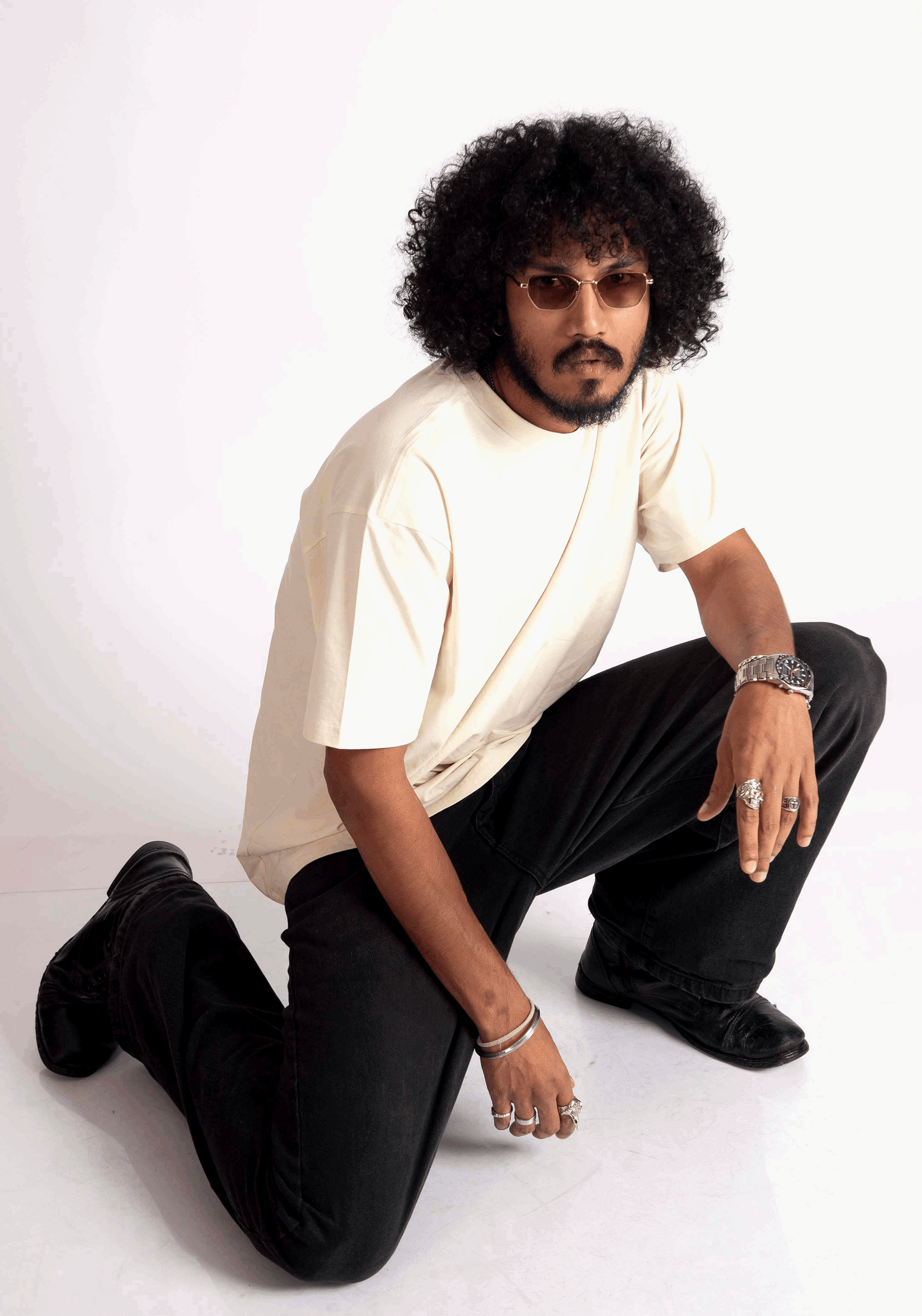 Man wearing oversized almond milk t-shirt paired with black pants and accessories