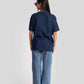 Back view of a woman wearing oversized blue graphic tee for womens paired with light blue wide-leg jeans