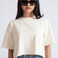 Stylera oversized crop top for women in cream color paired with blue jeans and black sunglasses