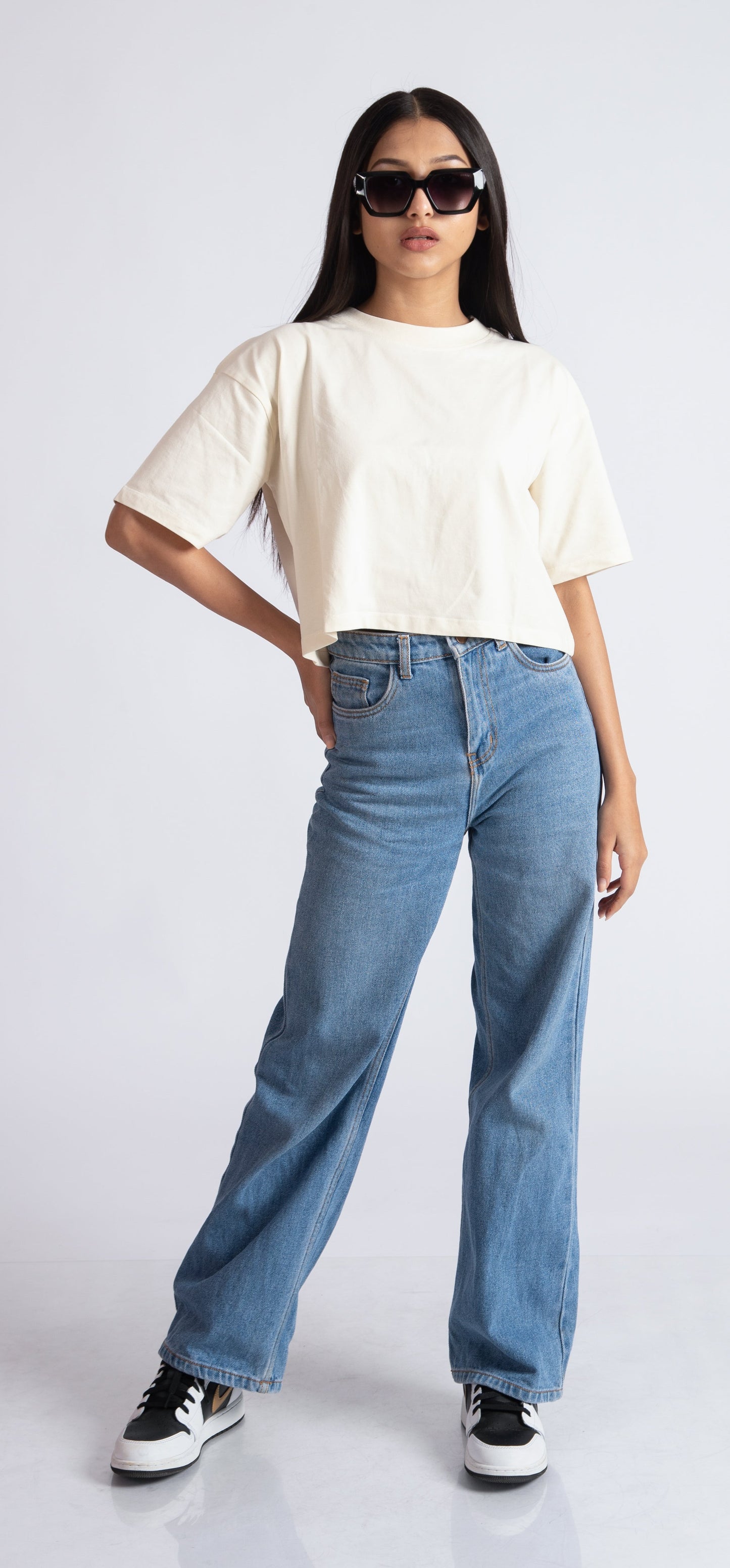 Stylera oversized crop top for women in white paired with high-waisted blue jeans