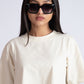 Stylera oversized crop top for women in off-white color worn with black sunglasses