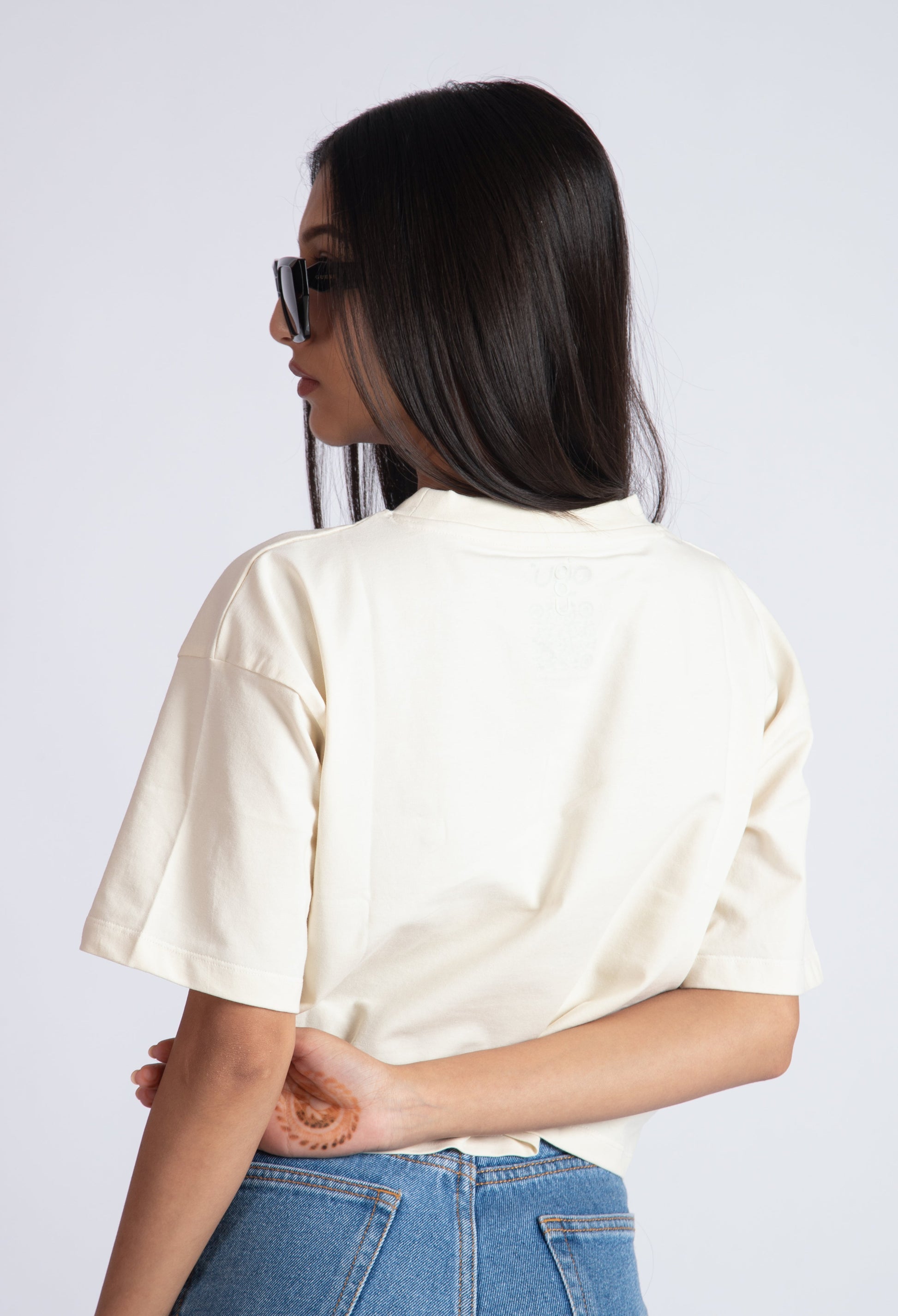 Stylera oversized crop top for women in cream color worn with blue jeans and sunglasses