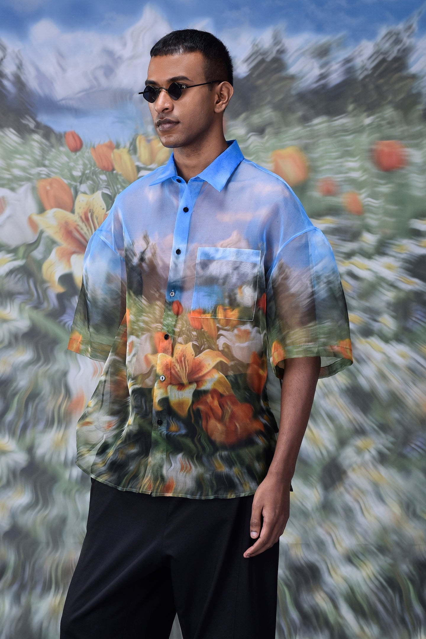 Stylera oversized floral button up shirt with blue sky and flower print on male model