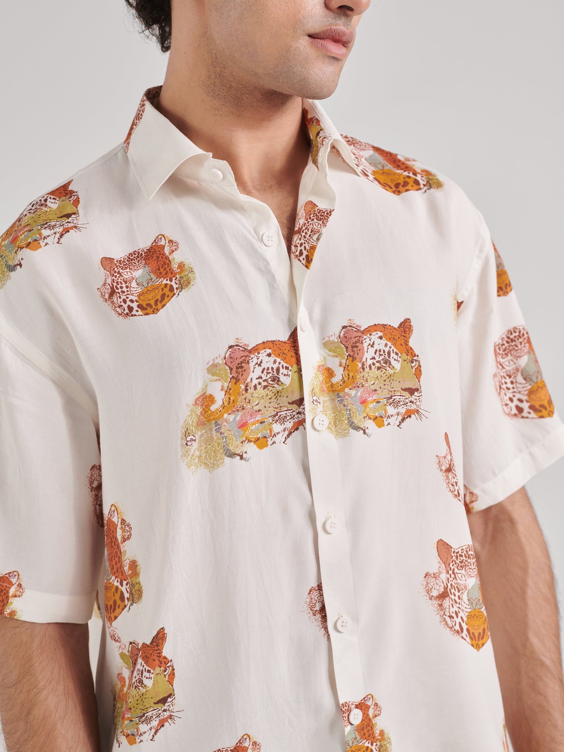 Men wearing an oversized leopard shirt for men with colorful leopard prints on a light background