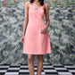 Peach casual dress with lace up front by Stylera worn by model with black hair