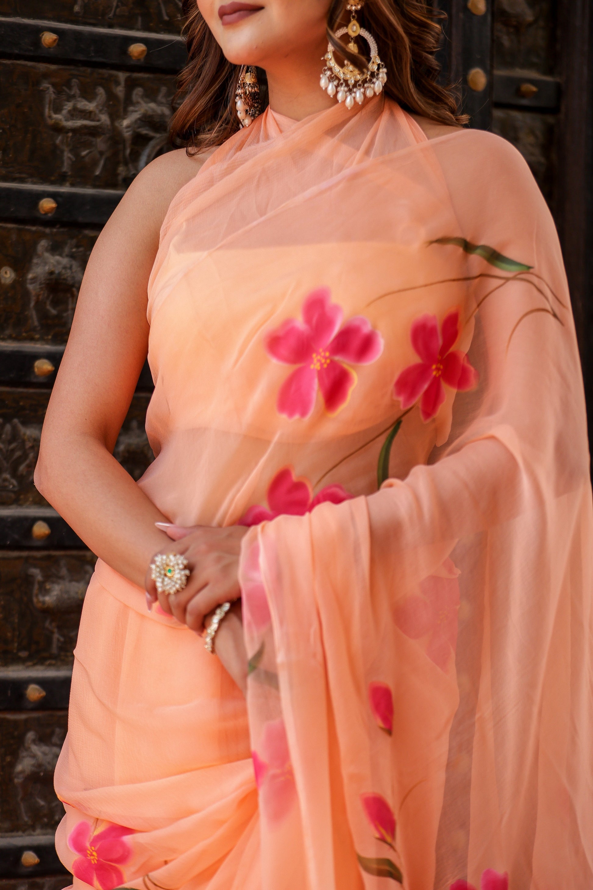 Elegant peach chiffon saree with floral design elegantly draped for a stunning look