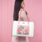 Peach crane paradise tote bag with floral design carried by a woman against a pink background