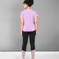 Back view of a woman in a Pilates pink t-shirt women paired with black leggings and white sneakers
