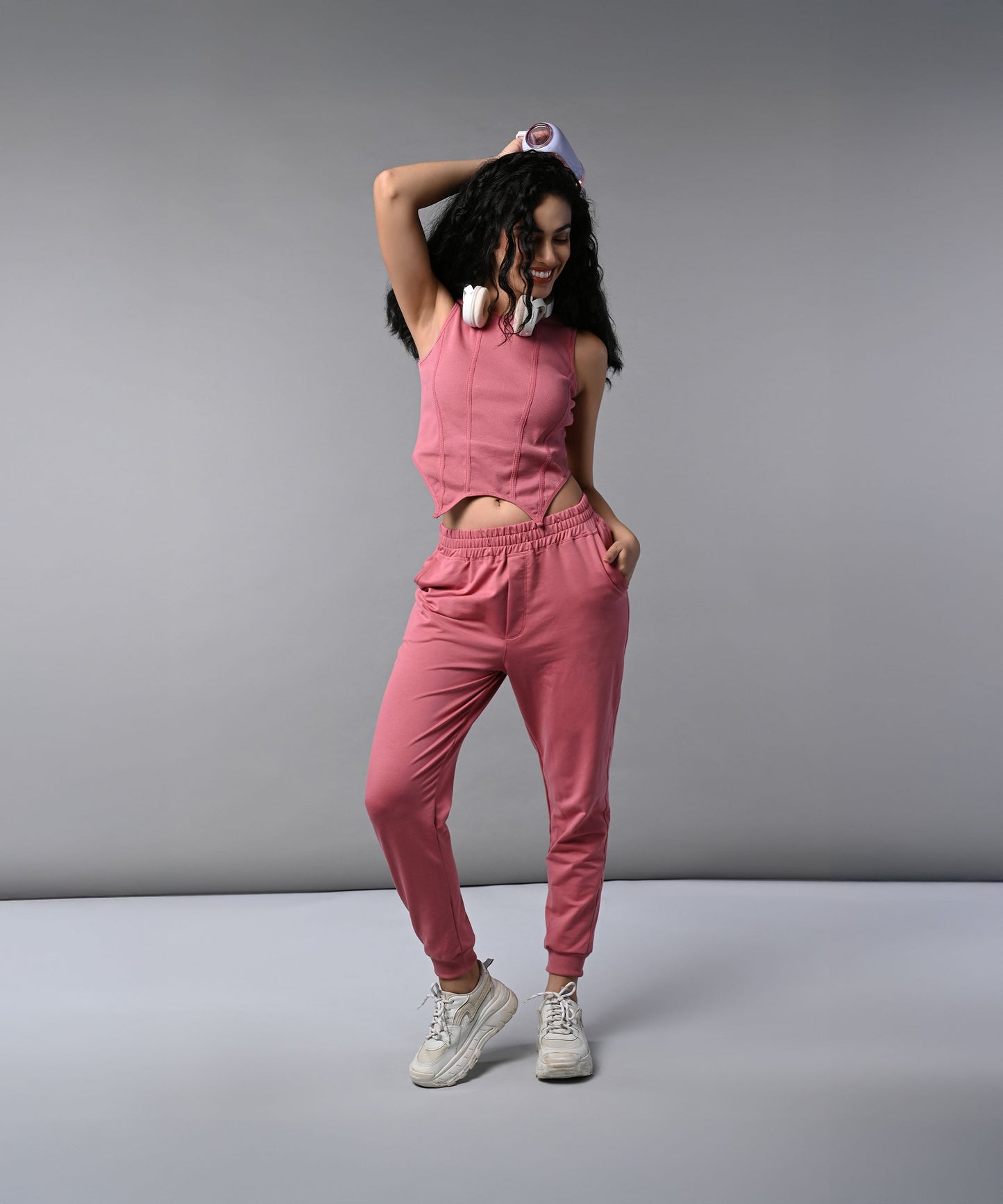 Model wearing a pink corset crop top with joggers, styled for a trendy outfit look