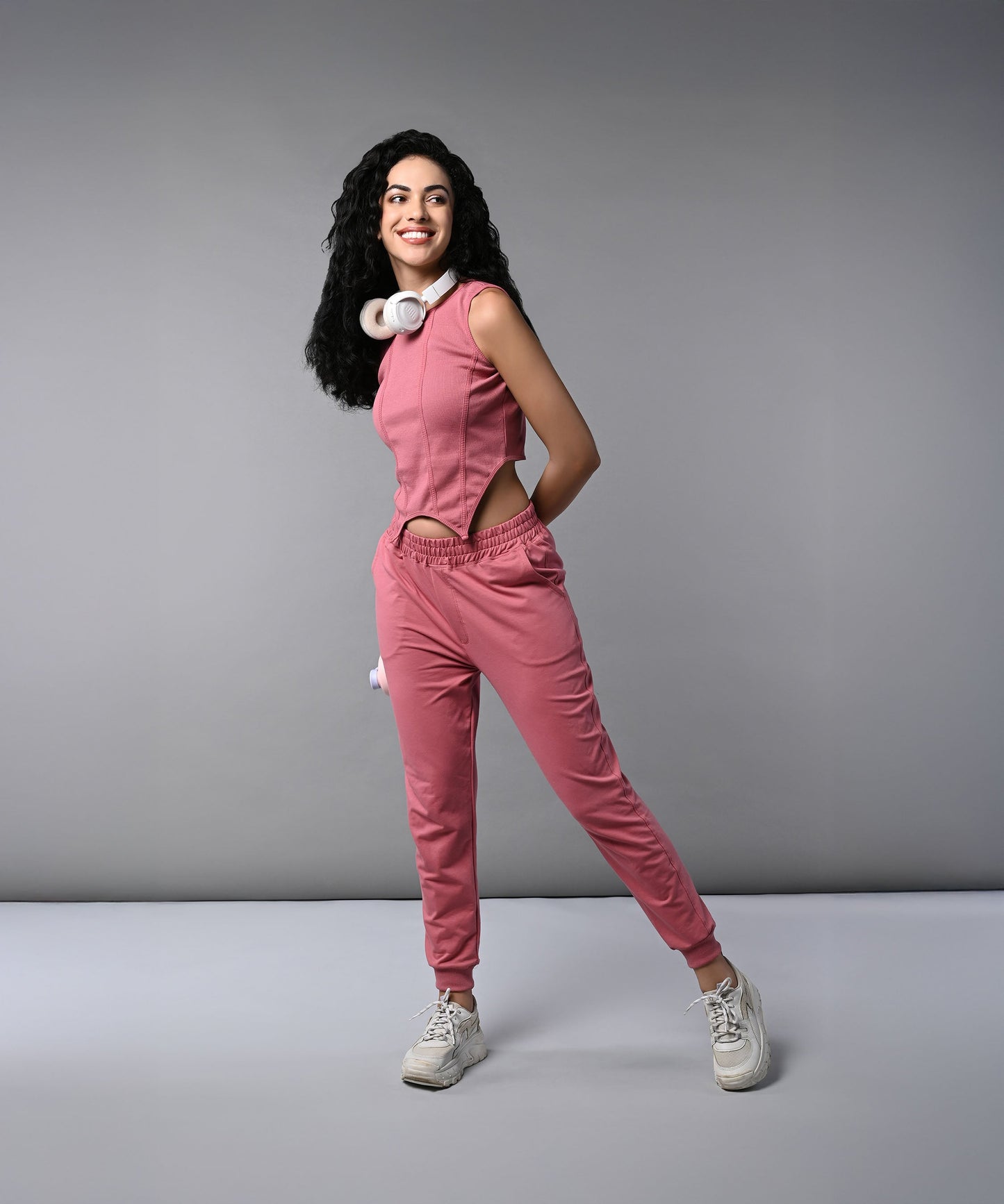 Model wearing a pink corset crop top with joggers, styled for a trendy look and comfort