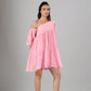 Stylera model wearing pink off shoulder dress with one puff sleeve and tiered mini skirt for summer events