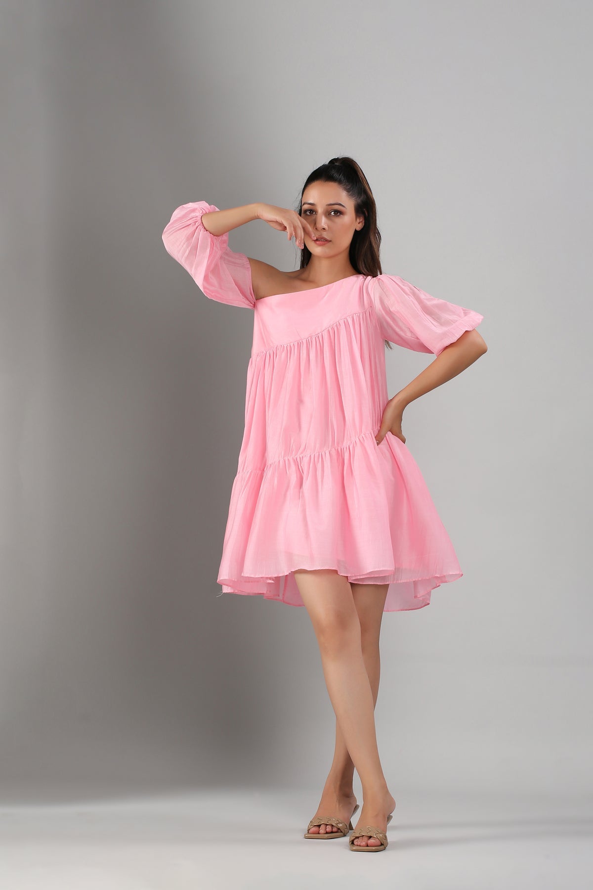 Model wearing Stylera pink off shoulder dress short tiered babydoll silhouette with puff sleeves and sandals