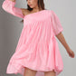 Stylera model wearing pink off shoulder dress loose tiered flowy fabric with elbow sleeves