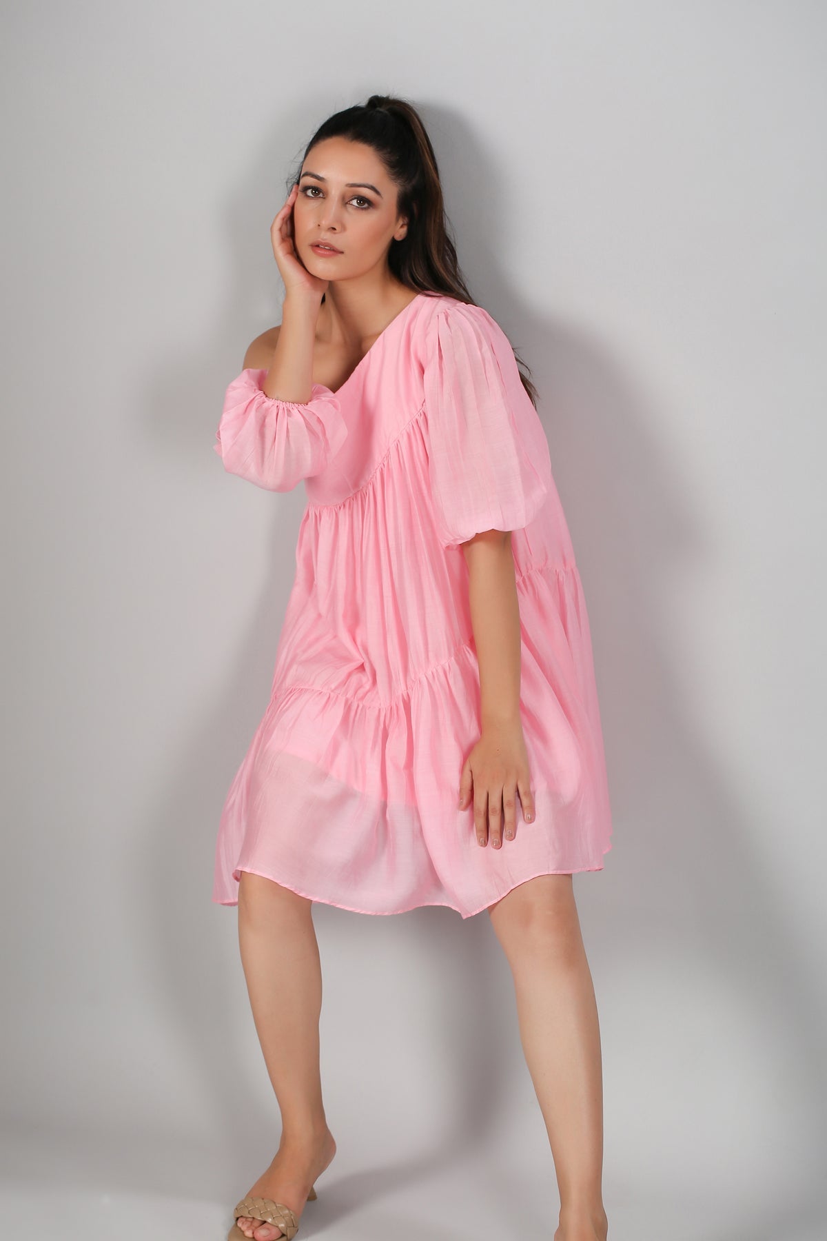 Stylera model wearing pink off shoulder dress tiered short silhouette with puff sleeves and relaxed fit