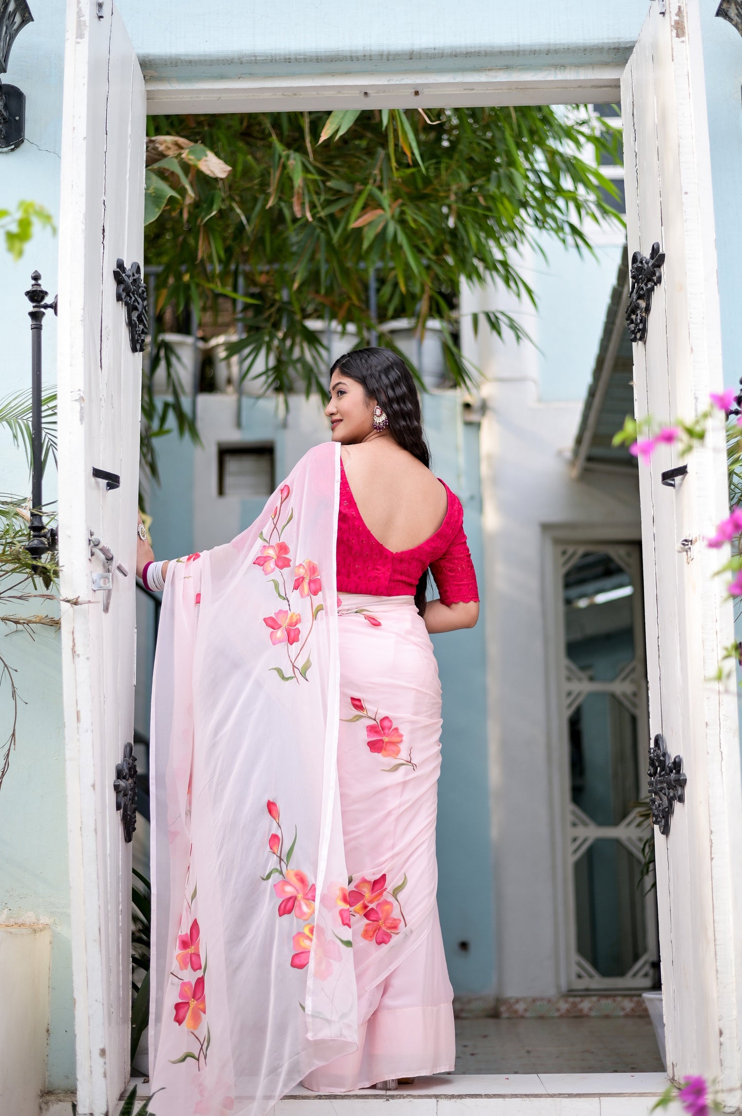 Elegant pink saree for women with floral embroidery, styled with a matching blouse and an open-back design