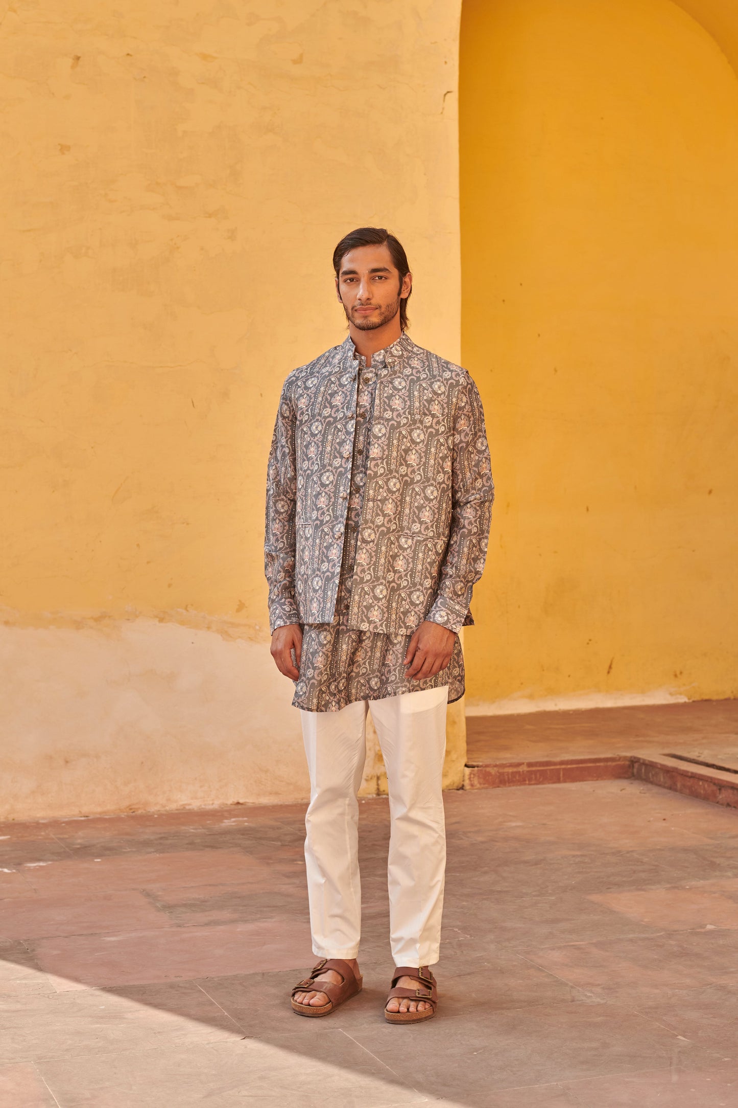 Stylish printed kurta and jacket for men in intricate patterns, paired with white trousers and sandals