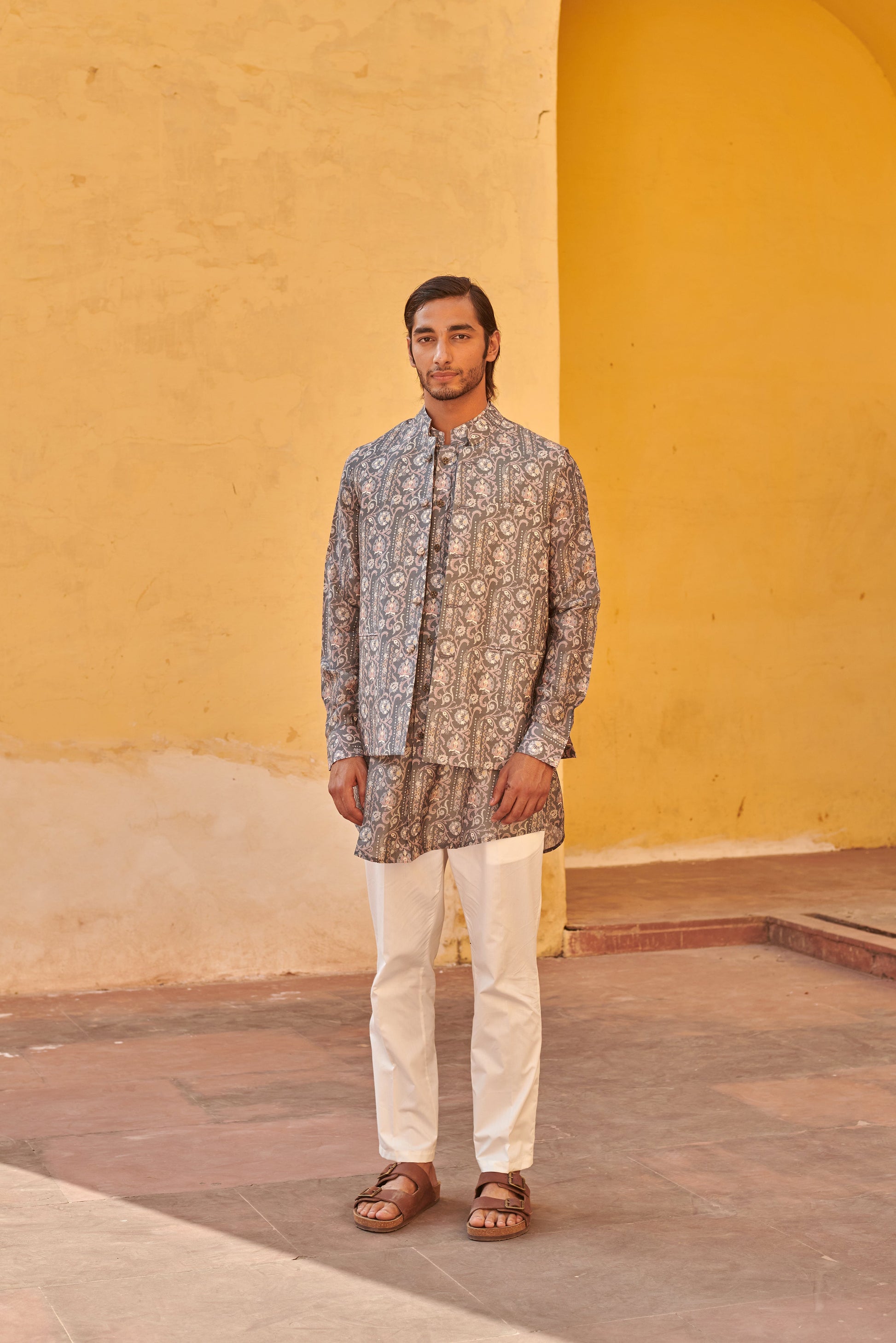 Stylish printed kurta and jacket for men in intricate patterns, paired with white trousers and sandals
