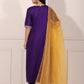 Back view of a purple and yellow ethnic suit set with intricate detailing and a flowing yellow dupatta