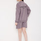 Model wearing Stylera purple sweatshirt for women with matching shorts and white sneakers