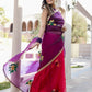 Stunning red and purple saree with handwork, worn elegantly by a model in a scenic outdoor setting