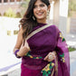 Beautiful red and purple saree with handwork worn elegantly, featuring floral design and accessories