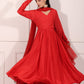 Model wearing a flowing red festive Anarkali gown, showcasing elegant design and graceful movement