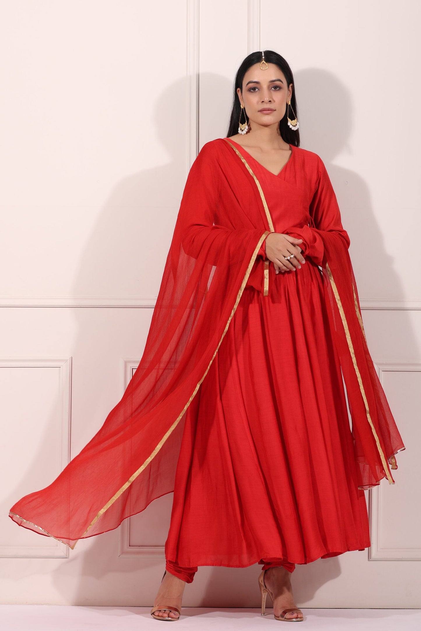 Elegant red festive Anarkali gown with flowing dupatta and intricate detailing for special occasions