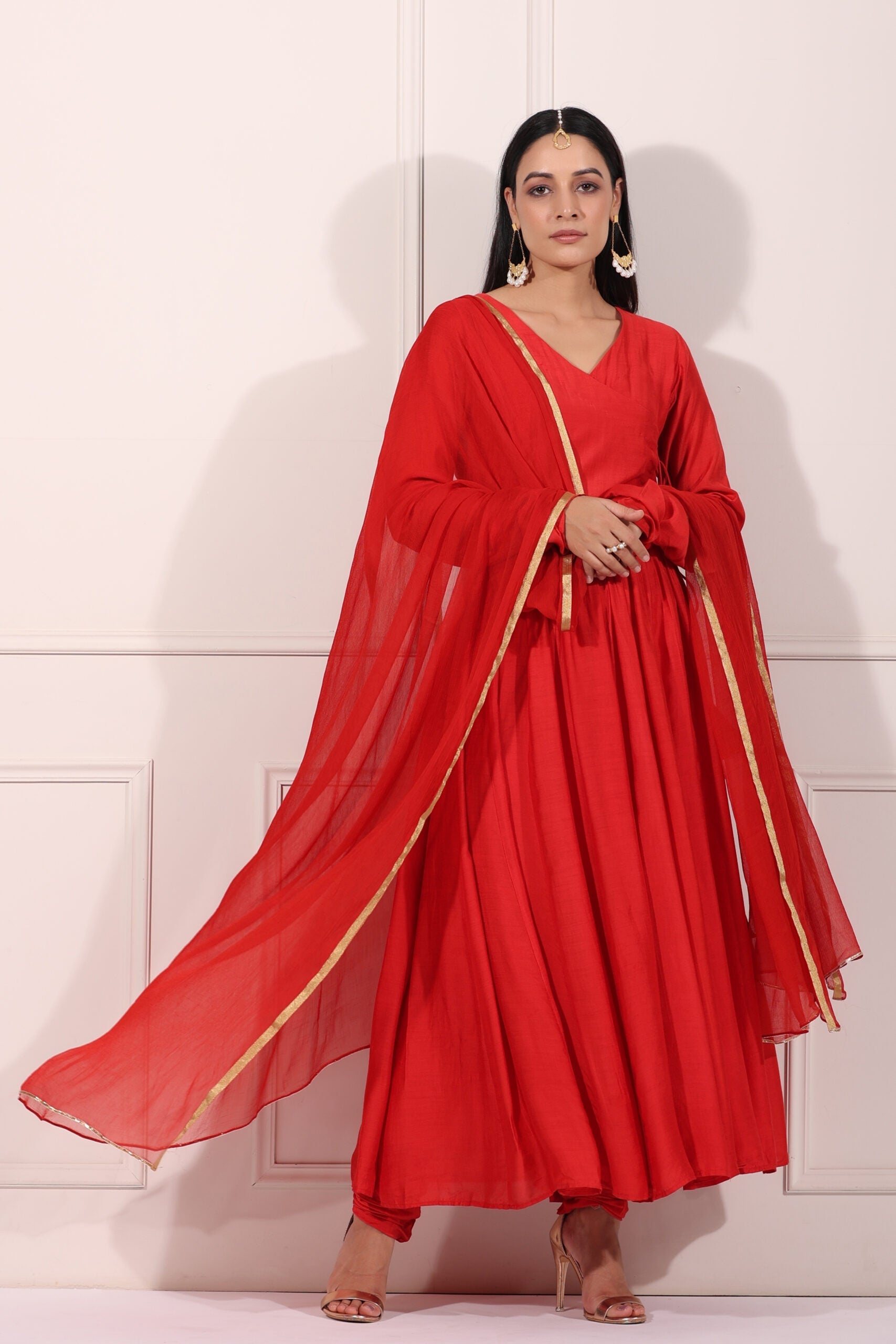Elegant red festive Anarkali gown with flowing dupatta and intricate detailing for special occasions