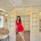 Model wearing Stylera red two piece set for women posing in airy vintage room with white sneakers