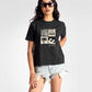 Stylera regular fit black t-shirt for women with graphic beach print worn with denim shorts