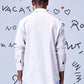 Back view of model wearing Stylera white regular fit men's shirt cotton with light blue trousers and doodle backdrop