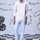 Male model wearing a pale pink button down regular fit men's shirt cotton with light blue trousers and white sneakers